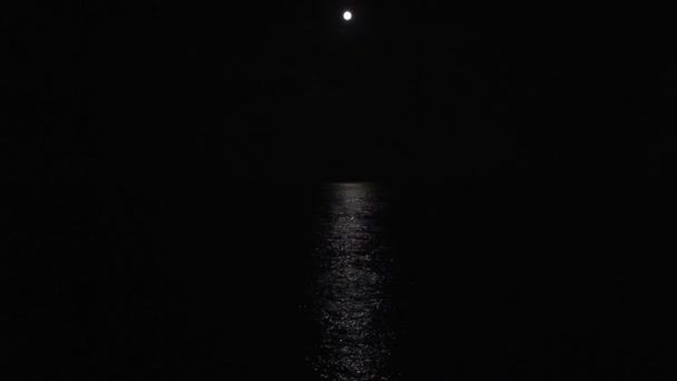 Luz de la luna reflejada en el mar por la noche — Vídeo de stock