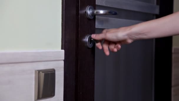 La chica abre y cierra la puerta del apartamento. La persona que usa la llave y cierra la puerta del apartamento — Vídeo de stock