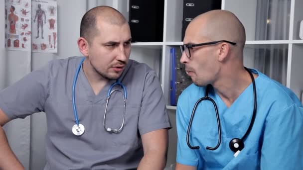 Medico maschio e giovane stagista di buon umore parlando di nuove ricerche mediche — Video Stock