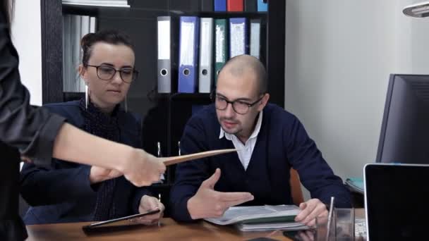 Um jovem chefe senta-se no escritório com seu assistente e discute o plano de trabalho — Vídeo de Stock