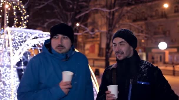 Két férfi kávézni téli este, a park közelében gyönyörű karácsonyi díszek télen
