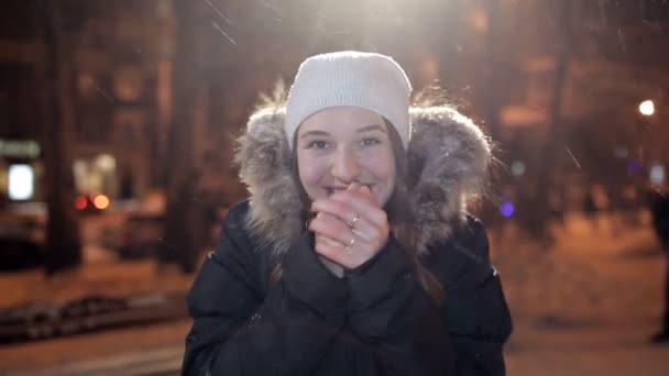 Mladá dívka pózuje na zimní večer na fotoaparátu. Je zima, zima — Stock video