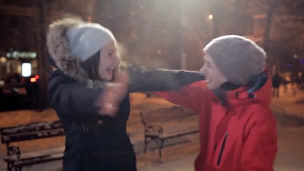 Две молодые девушки в зимний вечер, радостный и счастливый — стоковое видео