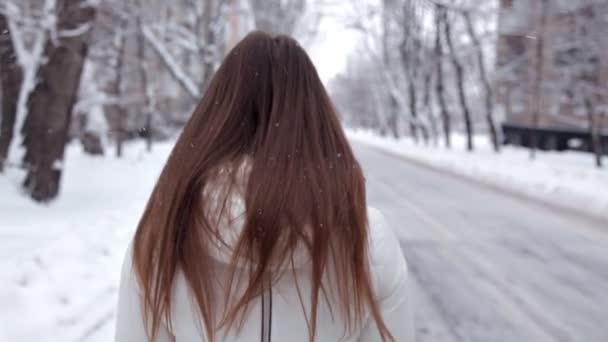 Una joven posa para la cámara en un frío día de invierno. Nieve fría — Vídeos de Stock