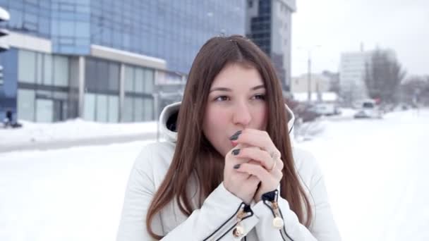 Uma jovem posa para a câmera em um dia frio de inverno. Neve fria — Vídeo de Stock