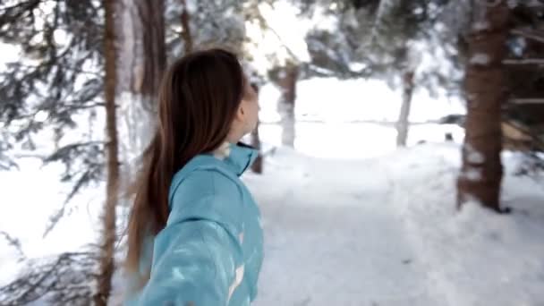 Bella donna a piedi tra gli alberi innevati nella foresta invernale e godersi la prima neve — Video Stock