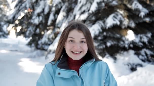 Egy fiatal lány sétál a téli abban az erdőben és a jelent, a kamera — Stock videók