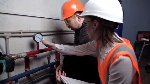 The inspector and the worker check the heating system. Beautiful woman engineer — Stock Footage The inspector and the worker check the heating system. Beautiful woman engineer Royalty Free Stock Video