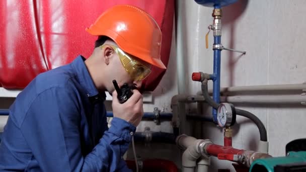 Ingenieur in glazen werken in de boilerkamer, controleert het onderhoud van de verwarming systeemapparatuur — Stockvideo