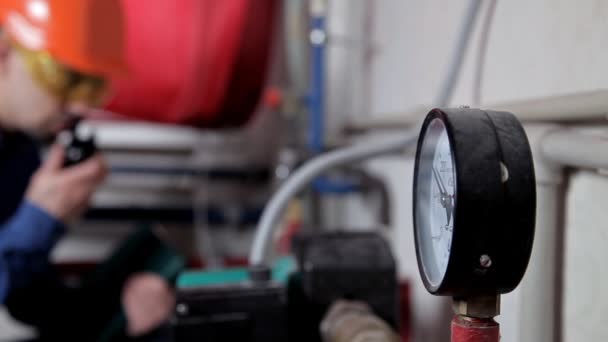 Um engenheiro de óculos trabalha na sala da caldeira, verifica a manutenção do equipamento do sistema de aquecimento — Vídeo de Stock