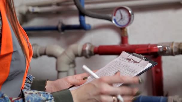 Engenheira verifica os dados do equipamento do sistema de aquecimento na sala da caldeira — Vídeo de Stock