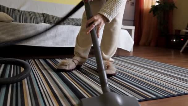 Молодая женщина с помощью пылесоса при уборке ковра в доме. — стоковое видео
