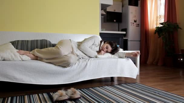 En ung tjej somnade på soffan i hem kläder. Vaknade efter sömn — Stockvideo