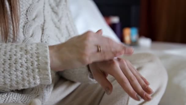 Beauty, people and health concept - Clean well-groomed hands of a young woman, applying hand cream, skin care on white background. — 图库视频影像