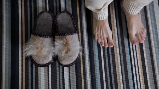 Des pantoufles sur le tapis. La fille met des chaussures à la maison. Confort, chaud — Video