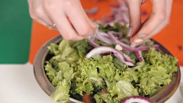 Kız bir salata yeşillikleri ve soğan hazırlar. Sağlıklı gıda — Stok video