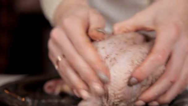 En ung flicka i köket lagar kyckling, gnugga den med kryddor. Middag — Stockvideo