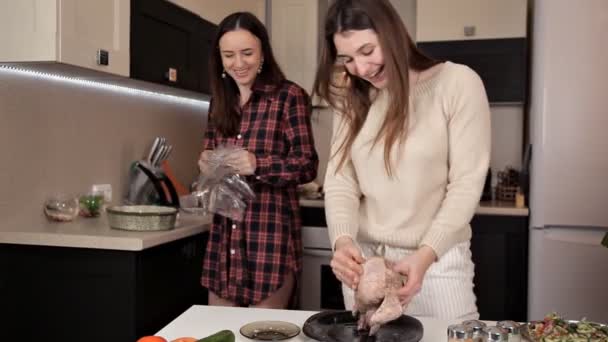 Two young girls prepare a festive dinner with chicken spices