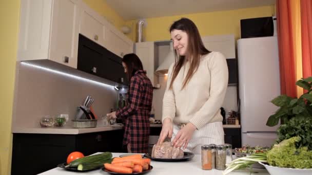 Two young girls prepare a festive dinner with chicken spices — Stock Video