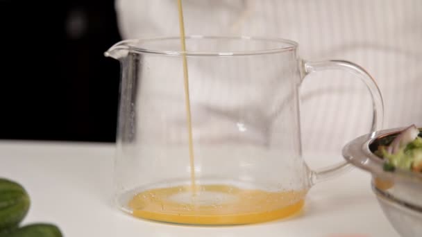 Свежий апельсиновый сок налили в стеклянную банку — стоковое видео
