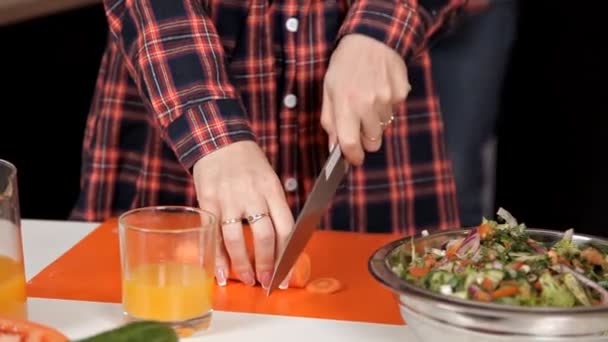 La chica de la cocina corta anillos de zanahoria. Comida, Ensalada — Vídeos de Stock