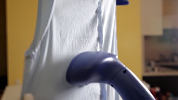 Una mujer usa vapor para planchar su blusa. El proceso de cocer al vapor la blusa con un limpiador de vapor. De cerca. — Vídeo de stock