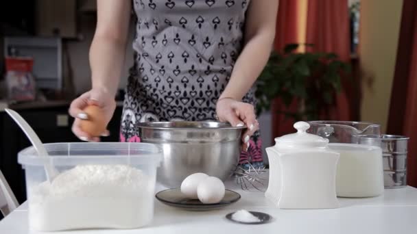 A menina quebra o ovo e adiciona à tigela de farinha, misturando todos os ingredientes — Vídeo de Stock