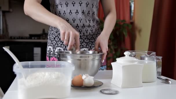 Flickan i köket skakar i en silverskål nödvändiga ingredienser för bakning. Begreppet av matlagning och bakning — Stockvideo