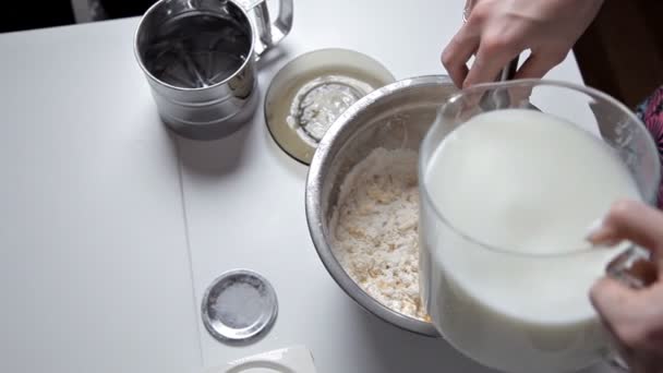 With womens hands, add the milk to the bowl and whisk. Cooking dough. homemade baking — Stock Video