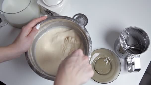 A lány a konyhában zavarja a tésztát habverővel a tej tömege — Stock videók