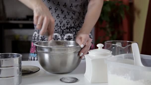 Девушка на кухне мешает молочной массе из тестового венчика — стоковое видео