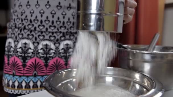 Mujer joven tamizando harina a través de un tamiz para hacer masa de pizza — Vídeos de Stock