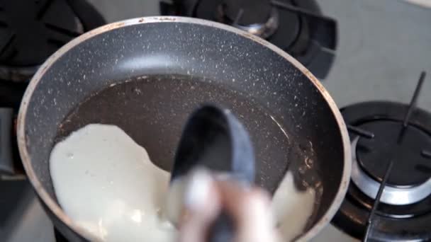 Наливание жидкого теста на горячую сковородку во время жарки блинов — стоковое видео