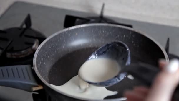 Wlewając płyn ciasta na gorącej patelni podczas smażenia naleśników — Wideo stockowe