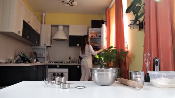 Zieht das Mädchen eine Zutat zum Backen aus dem Kühlschrank. kulinarische Zubereitung — Stockvideo