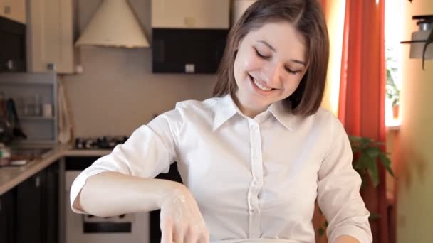 Uma jovem cansada manchou o rosto com massa. Ela usa muitos ingredientes e utensílios para amassar a massa — Vídeo de Stock