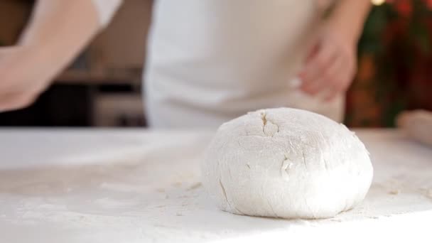 Uma jovem na cozinha preparou a massa para assar. Massa na mesa, temporizador para o teste — Vídeo de Stock