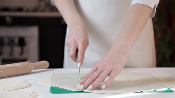 Fille coupes sur un vert Conseil dans la cuisine roulé pâte avec un couteau — Video