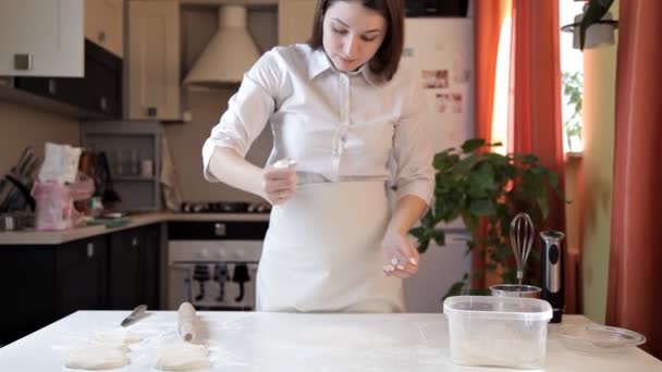 A rapariga do avental enrola a massa de pizza com um rolo. Cozinhar pizza em casa — Vídeo de Stock