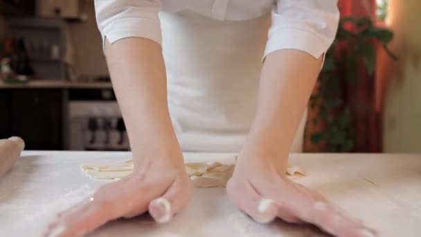 La chica del delantal cambia la masa y la corta. Cocinar pizza en casa — Vídeos de Stock