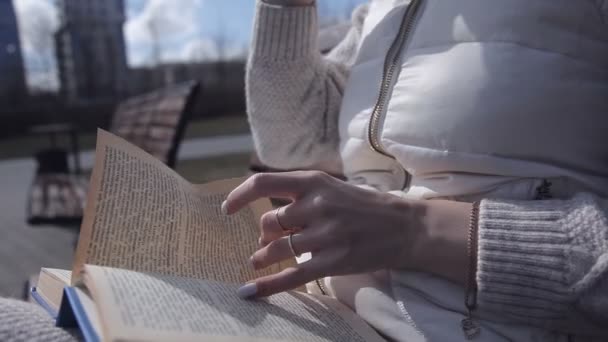 Close up. Schöne weibliche Finger beim Betrachten des Buches. die andere Hand hält einen Thermobecher — Stockvideo