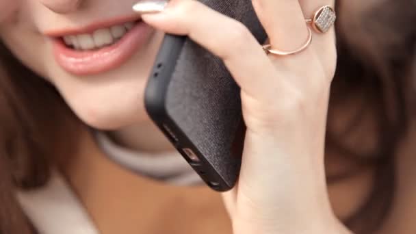 Beautiful woman talking on the phone. Portrait of talking woman smile. The concept of soft connections. The face of a girl talking to a friend on a smartphone — Stock Video