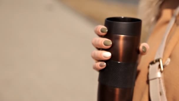 Una chica con una taza de café y verde oscuro, esmalte de uñas de color caqui. Concepto de manicura y otoño. De cerca. — Vídeo de stock