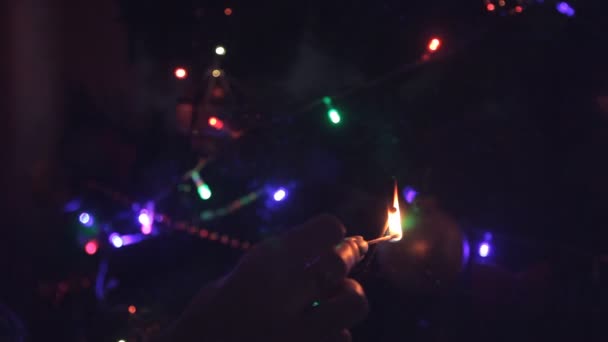 As mãos das mulheres incendiaram um Sparkler no fundo da árvore — Vídeo de Stock