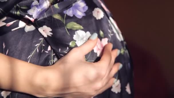 Беременная молодая девушка в шелковом халате осторожно и с любовью гладит живот — стоковое видео