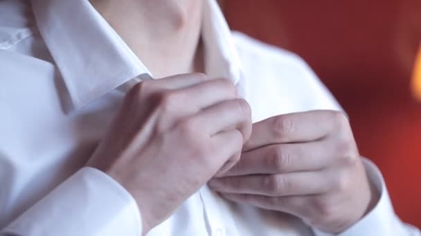 Ein Mann schnallt den Kragen eines weißen Hemdes an. Nahaufnahme — Stockvideo