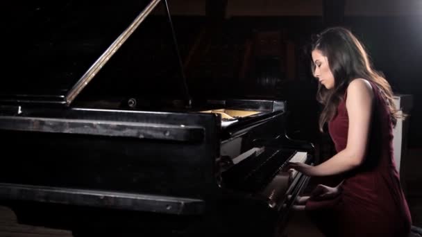 Красивая молодая женщина играет на пианино в концертном зале, репетирует — стоковое видео
