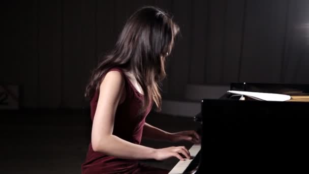 Όμορφη νεαρή γυναίκα που παίζει πιάνο στην αίθουσα συναυλιών, πρόβα — Αρχείο Βίντεο