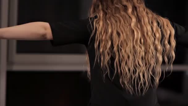 Fiatal lány hosszú hajjal fekete öltönyben vonatok a folyosón, energikus tánc — Stock videók