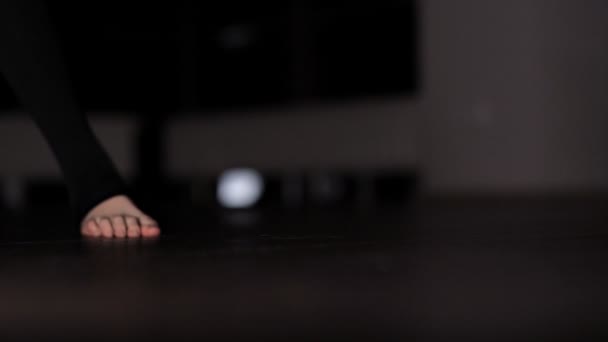 A tired girl after a dance rehearsal drinks water after a workout, sitting on a wooden floor in the gym — Stock Video